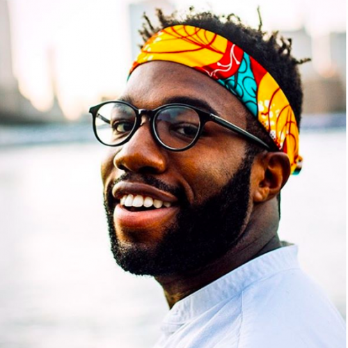 An image of Malcolm Thompson smiling with a colorful headwrap.