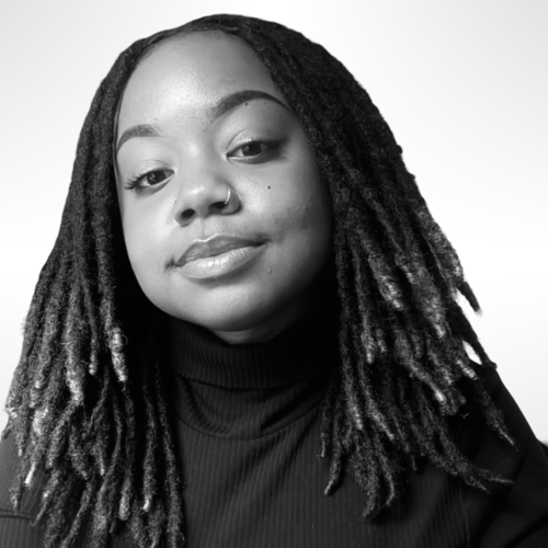 Black and white image of camille smiling at the camera in a black sweater